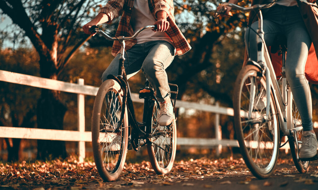 image of lower half of two adults riding their bikes in autumn